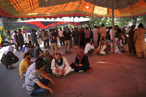 Protesters sit under a tent as the yplan to stay indefinitely near the Wednesday's suicide attack site
