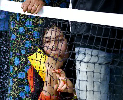 A displaced resident of Marawi city holds her coupon as they queue up to receive relief and food supplies at an evacuation center in Balo-i township