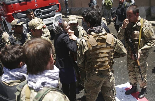 A woman tries to stop police from firing on protesters during a demonstration in Kabul