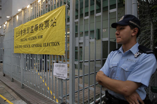A police officer stands outside a polling station for the legislative council election Sunday