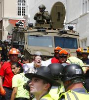 Rescue personnel help injured people after a car ran into a large group of protesters after an white nationalist rally in Charlottesville