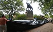 City workers prepare to drape a tarp over the statue of Confederate General Stonewall Jackson in Justice park in Charlottesville