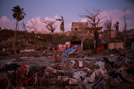 A boat lies washed up amidst Haitian army buildings damaged by Hurricane Matthew