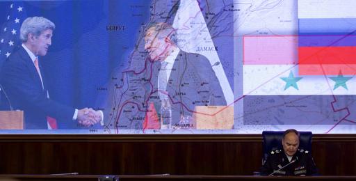 Russian Deputy Defense Minister Anatoly Antonov speaks with a montage showing Secretary of State John Kerry shaking hands with Russian Foreign Minister Sergey Lavrov at rear