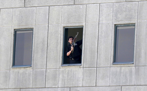 An armed man stands in a window of the parliament building in Tehran