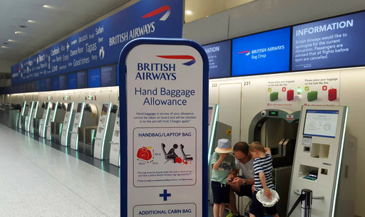 Passengers wait at a British Airways check-in desk after the airport suffered an IT systems failure