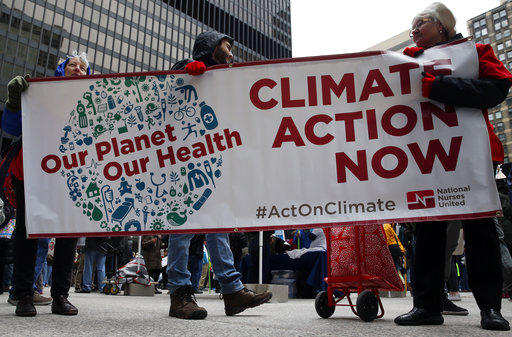 Demonstrators hold a sign during a "100 Days of Failure" protest and march