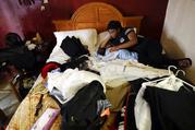 Jamica Batts sits on a hotel bed with her two-month-old baby Jarasiah Batts as they pack to leave Monday