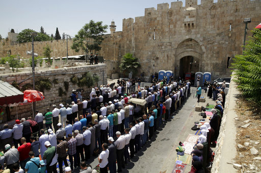 Palestinians pray outside the Lion's Gate in Jerusalem's Old City