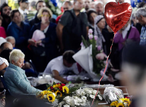 A balloon shaped like a heart and reading in Italian "Goodbye Anna" floats over caskets prior to a state funeral for some of the victims of last Wednesday's earthquake