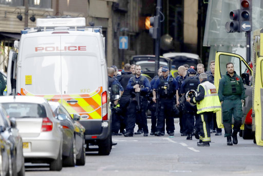 Armed British police officers walk within a cordoned off area after an attack in the London Bridge area in London