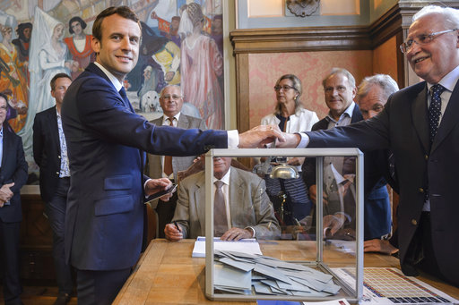 French President Emmanuel Macron casts his ballot in the first round of the two-stage legislative elections