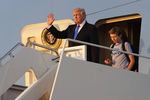 President Donald Trump waves in front of his son Barron as he steps off Air Force One after arriving at Andrews Air Force Base
