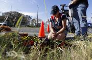 Rebecca Thompson prays at a makeshift memorial near the scene of a shooting at the First Baptist Church of Sutherland Springs to honor victims