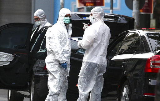 Greek police experts search for evidence at the scene of an explosion site in Athens