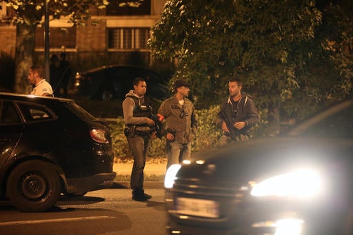 Police officers stand guard as they take part in a raid in Boussy-Saint-Antoine