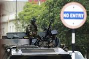 Soldiers sit on a military vehicle parked on a street in Harare