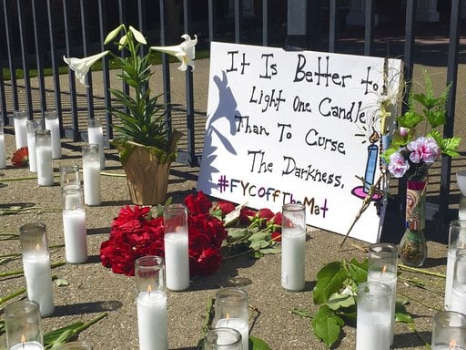 A memorial of candles and flowers honors victims of Tuesday's shooting outside Catholic Charities Wednesday