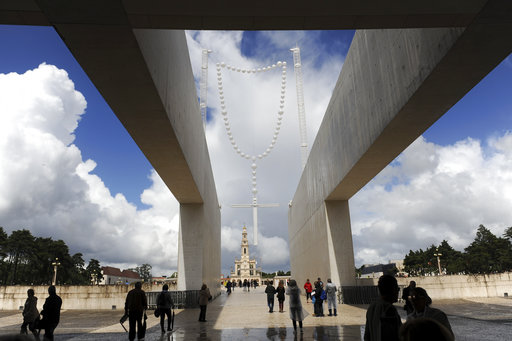 Pilgrims walk by a 26 metre tall giant glow-in-the-dark rosary