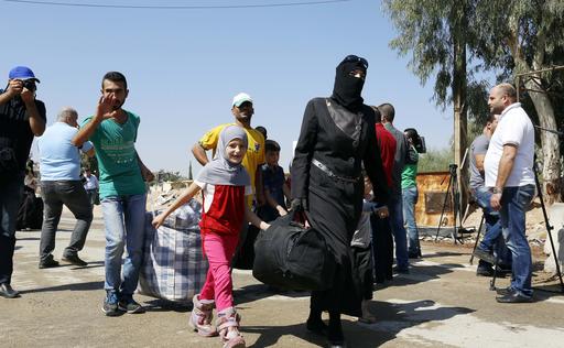 Syrians leave the Moadamiyeh suburb of Damascus