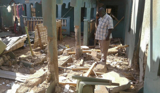 A man stands amid the debris at the scene of an attack in the town of Mandera