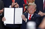 President Donald Trump holds up a signed proclamation to shrink the size of Bears Ears and Grand Staircase Escalante national monuments at the Utah State Capitol Monday