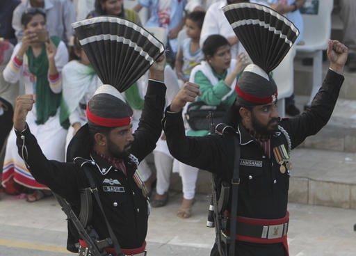 Pakistani border guards gesture while looking at their Indian counterpart during a daily border closing ceremony at sunset