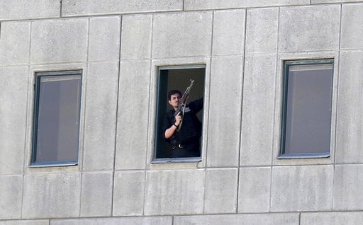 An armed man stands in a window of the parliament building in Tehran