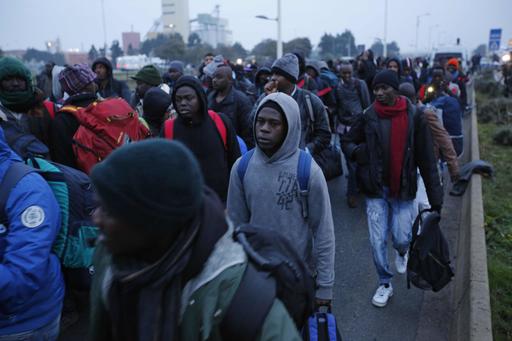 Migrants line-up to register at a processing centre in the makeshift migrant camp known as "the jungle" near Calais