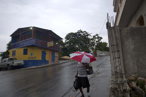 A woman walks with an umbrella as protection from a light rain