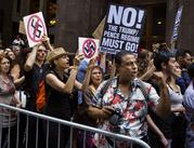 Protestors shout slogans in front of Trump Tower ahead President Donald Trump's visit to the building New York