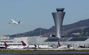 The air traffic control tower is in sight as a plane takes off from San Francisco International Airport