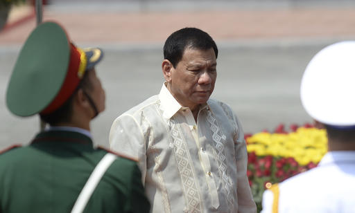 Philippine President Rodrigo Duterte reviews an honor guard with his Vietnamese counterpart Tran Dai Quang during a welcome ceremony at the presidential palace in Hanoi
