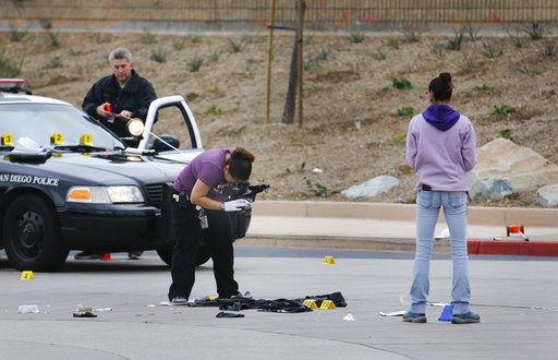 Members of the San Diego Police Department collect evidence at the scene of a fatal police officer involved shooting of a 15-year-old boy in one of the parking lots in front of Torrey Pines High School