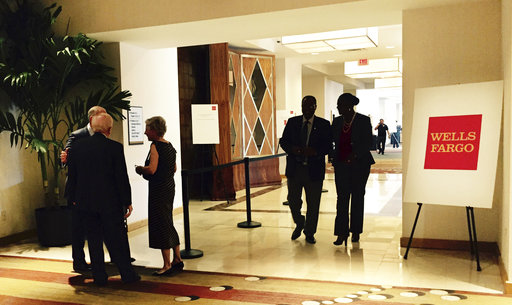 People stand and walk near the entrance to the Wells Fargo shareholders meeting in Ponte Vedra Beach