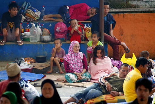 Displaced Marawi city residents rest on tarpaulin and corrugated boxes at an evacuation center in Saguiaran township