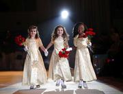 The ladies in waiting of the royal court of the Krewe of Little Rascals walk for the audience during their Mardi Gras Ball in Kenner