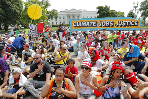 Demonstrators sit on the ground along Pennsylvania Ave. in front of the White House in Washington