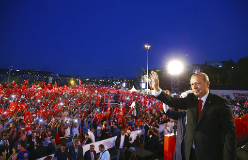 Turkey's President Recep Tayyip Erdogan waves to his supporters as he arrives to commemorate the one year anniversary of the July 15
