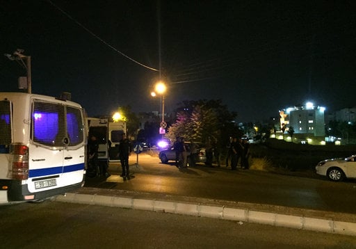 Security officials park near the approach toward the Israeli embassy in Amman
