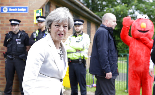 Britain's Prime Minister Theresa May leaves after voting in the general election as a person wearing a costume of childrens' TV character Elmo waves at polling station in Maidenhead