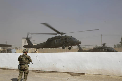 A helicopter belonging to the international coalition forces takes off from a base outside Mosul