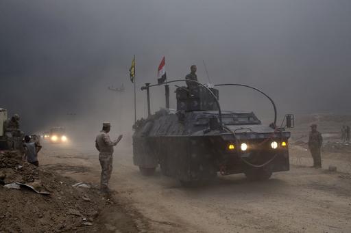 An Iraqi Federal Police vehicle passes through a checkpoint in Qayara