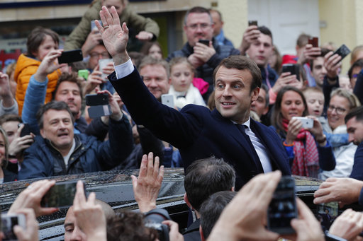 French independent centrist presidential candidate Emmanuel Macron waves as he leaves the polling station after casting his ballot in the presidential runoff election in Le Touquet