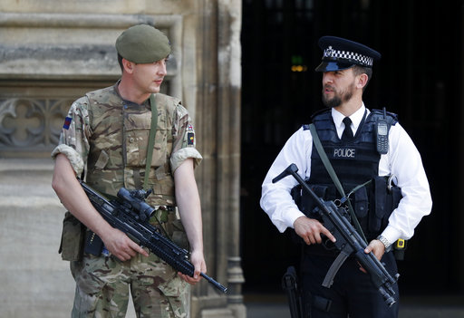 An armed soldier and policeman stand guard at Parliament