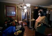 Lois Rose looks over belongings while salvaging items from her flood-damaged house Thursday