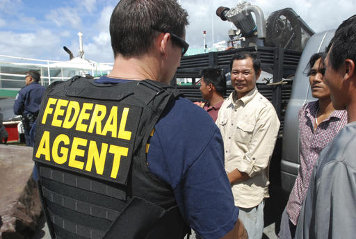 A Federal law enforcement officer talks to foreign fishermen in Hawaii's commercial fleet during a vessel inspection on Thursday