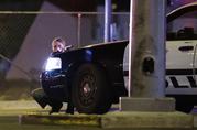A police officer takes cover behind a police vehicle during a shooting near the Mandalay Bay resort and casino on the Las Vegas Strip