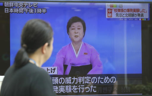 A woman watches a large TV screen showing Korea Central Television's news program on the North Korea's nuclear test