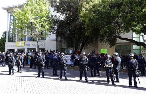 Police form a line in front of Berkeley High School as a rally for free speech takes place across the street Thursday